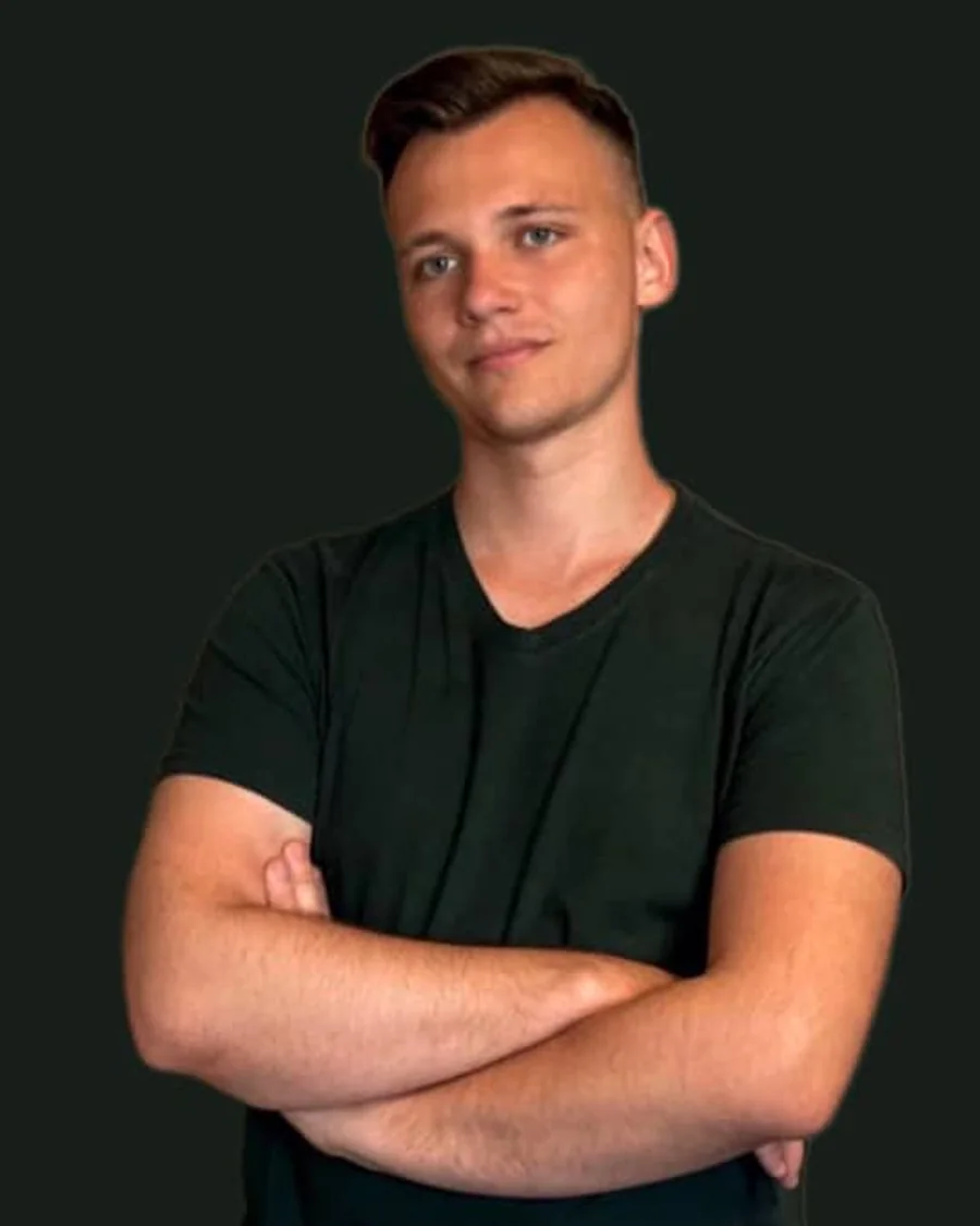 Yurii, massage therapist, standing with his arms folded